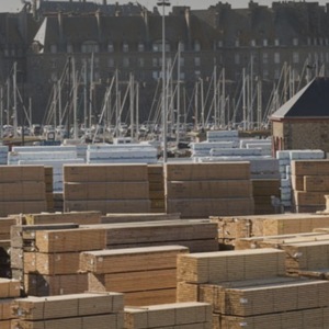 Vue d'un quai de stockage de bois d'importation avec un port à l'arrière plan
